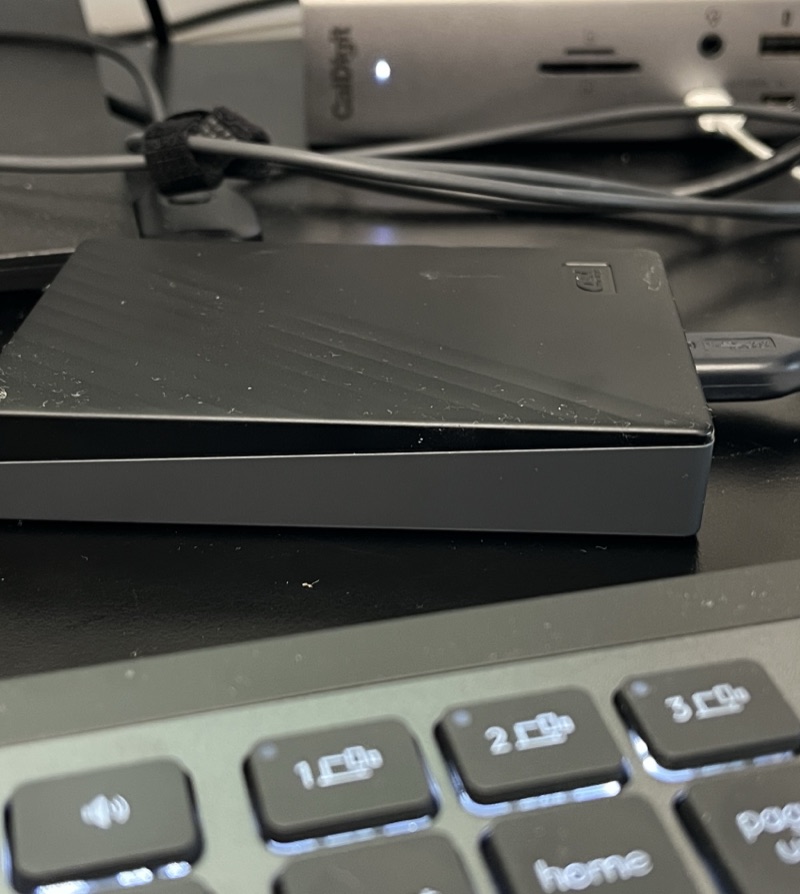 A portable backup drive plugged in on Julie's desk.